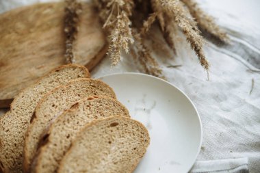 Beyaz bir masa örtüsünün üzerinde dilimlenmiş ekmek.