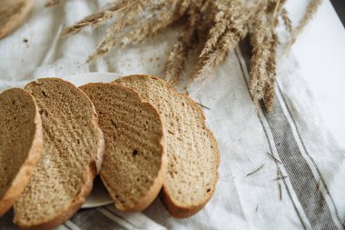 Beyaz bir masa örtüsünün üzerinde dilimlenmiş ekmek.