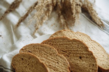 Beyaz bir masa örtüsünün üzerinde dilimlenmiş ekmek.