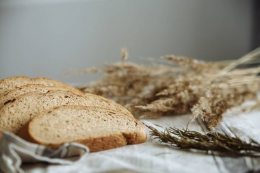 Beyaz bir masa örtüsünün üzerinde dilimlenmiş ekmek.