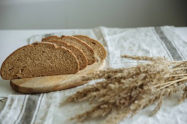 Beyaz bir masa örtüsünün üzerinde dilimlenmiş ekmek.