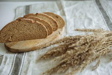 Beyaz bir masa örtüsünün üzerinde dilimlenmiş ekmek.