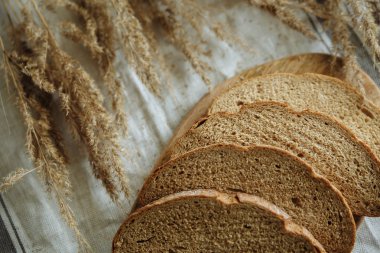 Beyaz bir masa örtüsünün üzerinde dilimlenmiş ekmek.