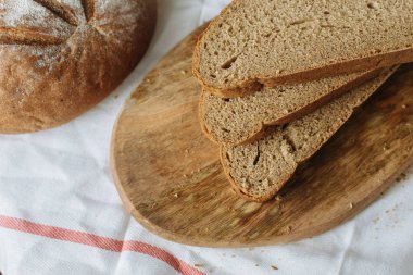 Dilimlenmiş ekmek ve kulaklar beyaz masa örtüsünde