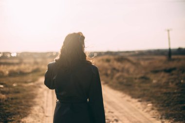 Kız siyah pelerin bırakıyor gün batımı kuru çim tarlası