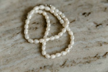 Mermer masa arkasında beyaz inci kolye