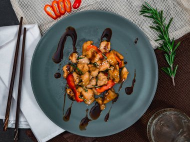 Soya soslu tavuk ve mavi tabakta çubuk. Çin yemeği, baharatlı öğle yemeği..