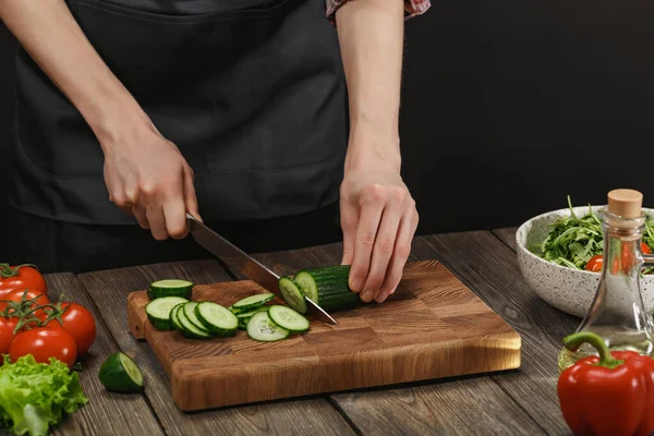 Женщина готовит свежий здоровый салат. Женские руки режут овощи на борту деревянного стола с копирайтом . — стоковое фото
