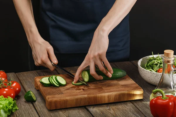 Женщина готовит свежий здоровый салат. Женские руки режут овощи на борту на деревянном столе . — стоковое фото