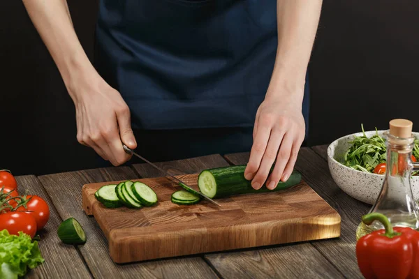 Женщина готовит свежий здоровый салат. Женские руки режут овощи на борту на деревянном столе . — стоковое фото