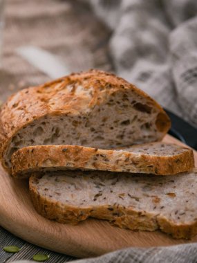 Tahta masadaki tahtanın üzerinde tam buğday ekmeği dilimlenmiş. Yukarıdan dikey çekim.