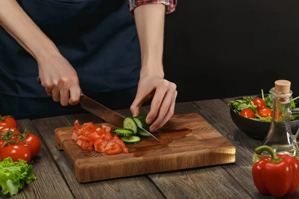 Donna che cucina insalata di verdure fresche. Mani femminili. Concetto di dieta per uno stile di vita sano con copyspace . Immagine Stock
