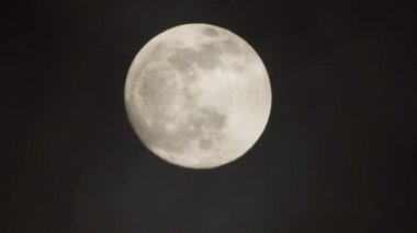 Karanlık bulutlu bir gecede dolunay. Ay 'ın yanından geçen bulutlar, gerçek zamanlı çekim.