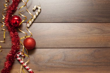 Ahşap arka plan, kırmızı Noel oyuncakları, çelenkler ve parlak toplarla süslenmiş. Noel ya da Yeni Yıl kavramı.