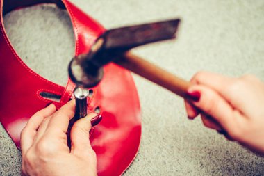 Deri ile çalışan ve el işi aletleri kullanan kadın ayakkabıcı.