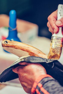 Tecrübeli bir ayakkabıcının elleri tutkal sürüyor.