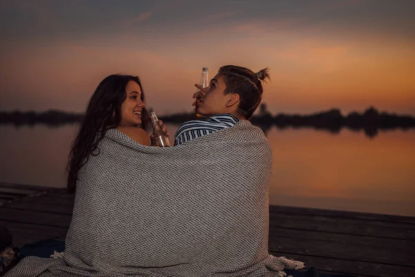 Giovane coppia che ha un appuntamento romantico vicino al fiume durante il tramonto , — Foto Stock