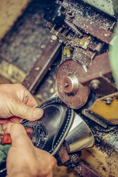 Manos de un zapatero experimentado terminando las suelas del sho — Foto de Stock