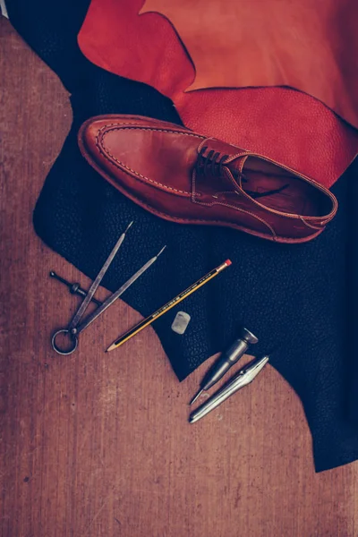 Man classic brown shoes and leather shoemaking tools and set of