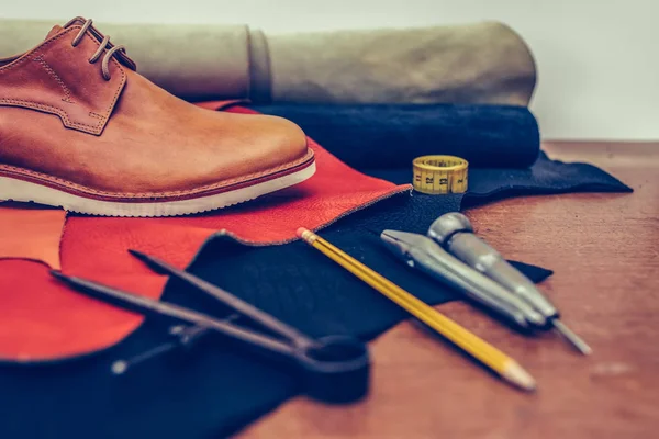 Classic brown shoes and leather shoemaking tools and set of leat