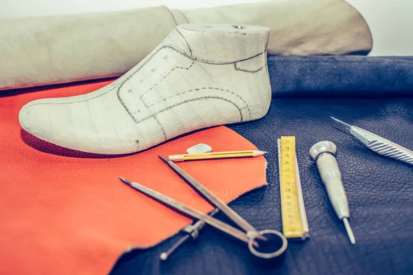 Lugar de trabajo del zapatero con herramientas, cuero y zapatos . — Foto de Stock