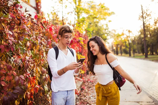 Feliz alegre jovem casal rindo segurando telefone falando sobre f — Fotografia de Stock