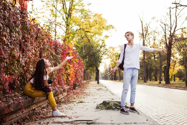 Dziewczyna i facet rozmawiają czekając na taksówkę — Zdjęcie stockowe