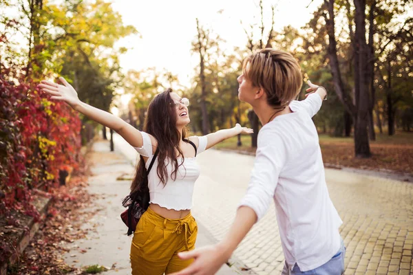 Молодой человек встречается со своей девушкой с распростертыми объятиями, на открытом воздухе — стоковое фото