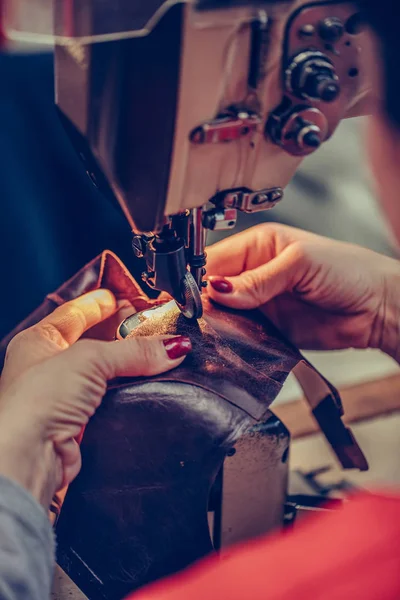Manos femeninas cosiendo una parte del zapato en un taller — Foto de Stock