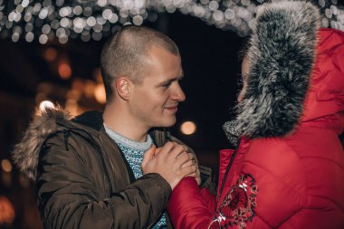 Birbirine aşık neşeli çift sarılıp, öpüşüp, eğleniyor.