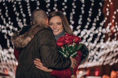 Genç romantik çift kışın dışarıda sarılıp öpüşüyor. 