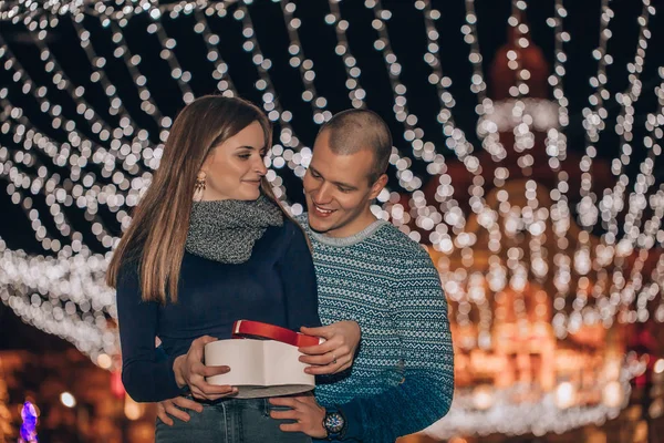 Jovem dá uma mulher xmas presente noite de inverno — Fotografia de Stock