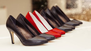 Bir rafta duran yüksek topuklu deri ayakkabı koleksiyonu.