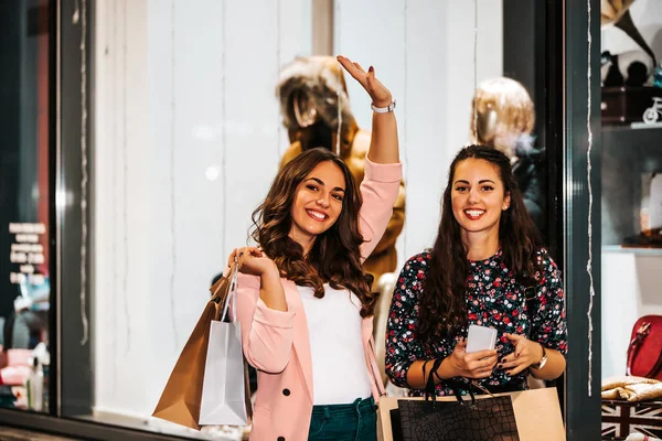 Due donne felici con shopping bags godendo nello shopping, avendo — Foto Stock