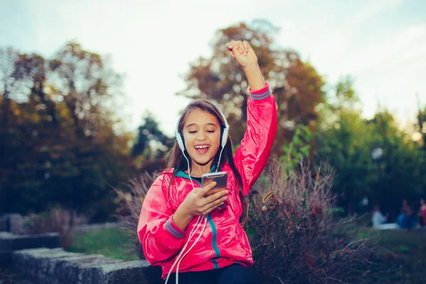 Excited little girl dancing, singing and listening music with he