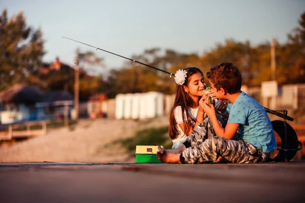 两个年轻可爱的小朋友 男孩和女孩在阳光明媚的夏日吃三明治 在湖里钓鱼 孩子们在玩友谊 — 图库照片