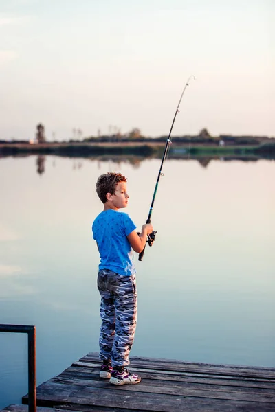 一个拿着钓竿的快乐小男孩 在阳光明媚的夏日 可爱的孩子在湖上钓鱼 — 图库照片