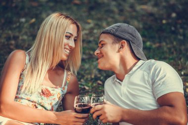 Bir bardak şarap bir parkta romantik bir piknik üzerinde zevk mutlu genç Çift