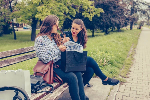 買い物の後に休憩 買い物をした後 公園のベンチに座って お互いに新しい購入を共有する2人の美しい女性 消費者主義 ショッピング ライフスタイルコンセプト — ストック写真