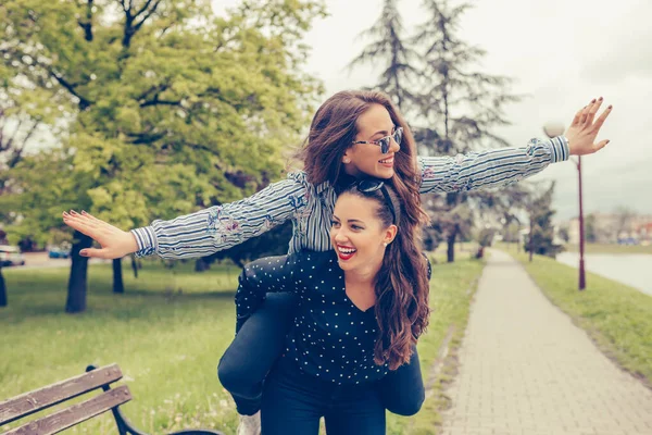 Jovem Mulher Feliz Carregando Seu Amigo Feminino Animado Suas Costas — Fotografia de Stock