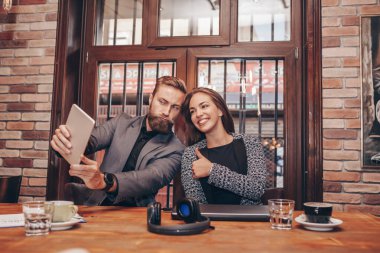 Güzel genç iş adamları dijital tablet kullanma ve kahve brea sırasında gülümseyen selfie yapıyoruz