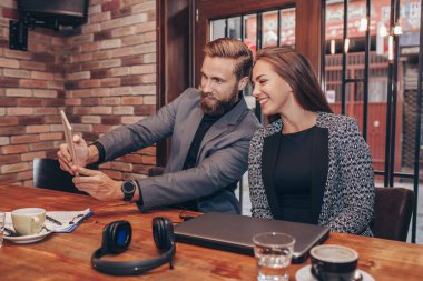 Güzel genç iş adamları dijital tablet kullanma ve kahve brea sırasında gülümseyen selfie yapıyoruz