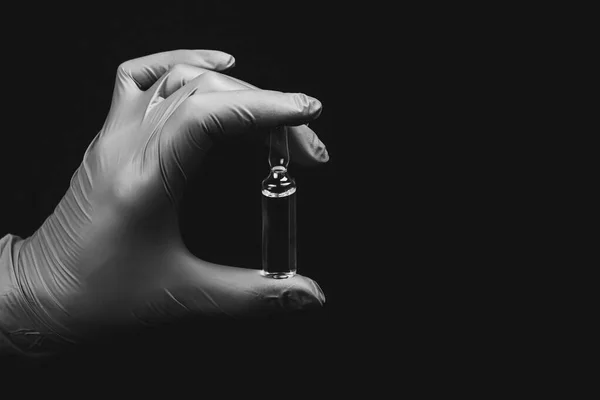 Kéz Kézben Steril Kesztyű Kezében Egy Orvosi Ampulla Fekete Alapon — Stock Fotó