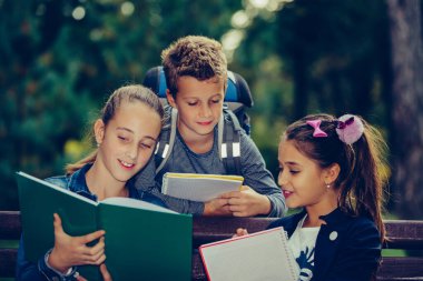Okula dönelim. Sırt çantalı çocuklar eğleniyorlar, konuşuyorlar, kitap okuyorlar. Bir grup ilkokul öğrencisi okuldan eve dönerken ödevlerini tartışıyorlar. Seçici odak