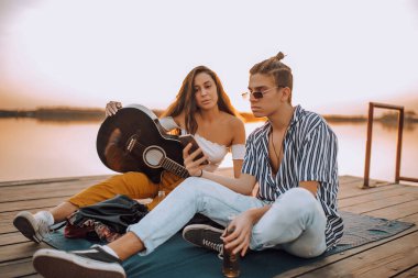 Nehir kenarında romantik bir buluşma yaşarken cep telefonuna bakan güzel bir çift..