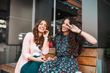 İki mutlu kadının görüntüsü - kulaklıkla müzik dinleyen arkadaşlar.