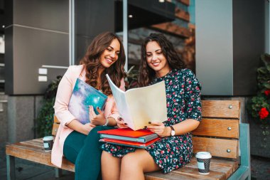 İki güzel kız arkadaş, öğrenciler sınavdan önce kağıt notları kontrol.