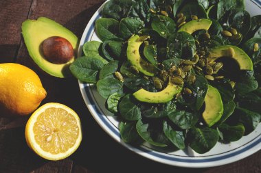 Avokado, ıspanak ve balkabağı tohumlu zeytinyağı ve limon suyuyla tatlandırılmış faydalı bir salata. Sağlıklı yemek..