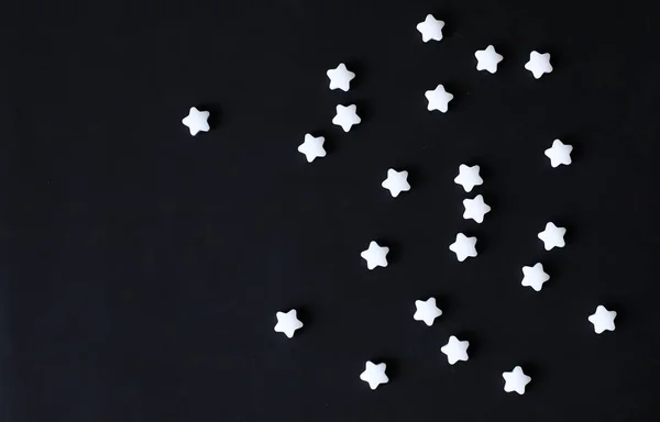 White stars on black background. Cool children background. White mint star candies. For banner, poster, greeting card, party invitation.