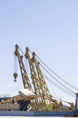 Mavi gökyüzüne karşı büyük iskele vinçleri. Vinçteki inşaat elemanlarının yakın plan görüntüsü.